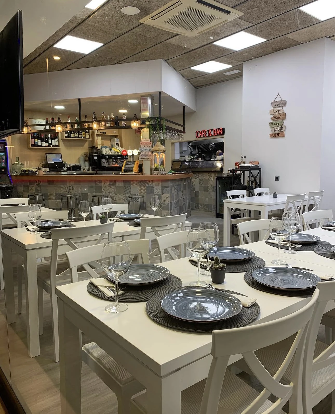 Salón interior de Barloa con mesas blancas montadas y barra al fondo