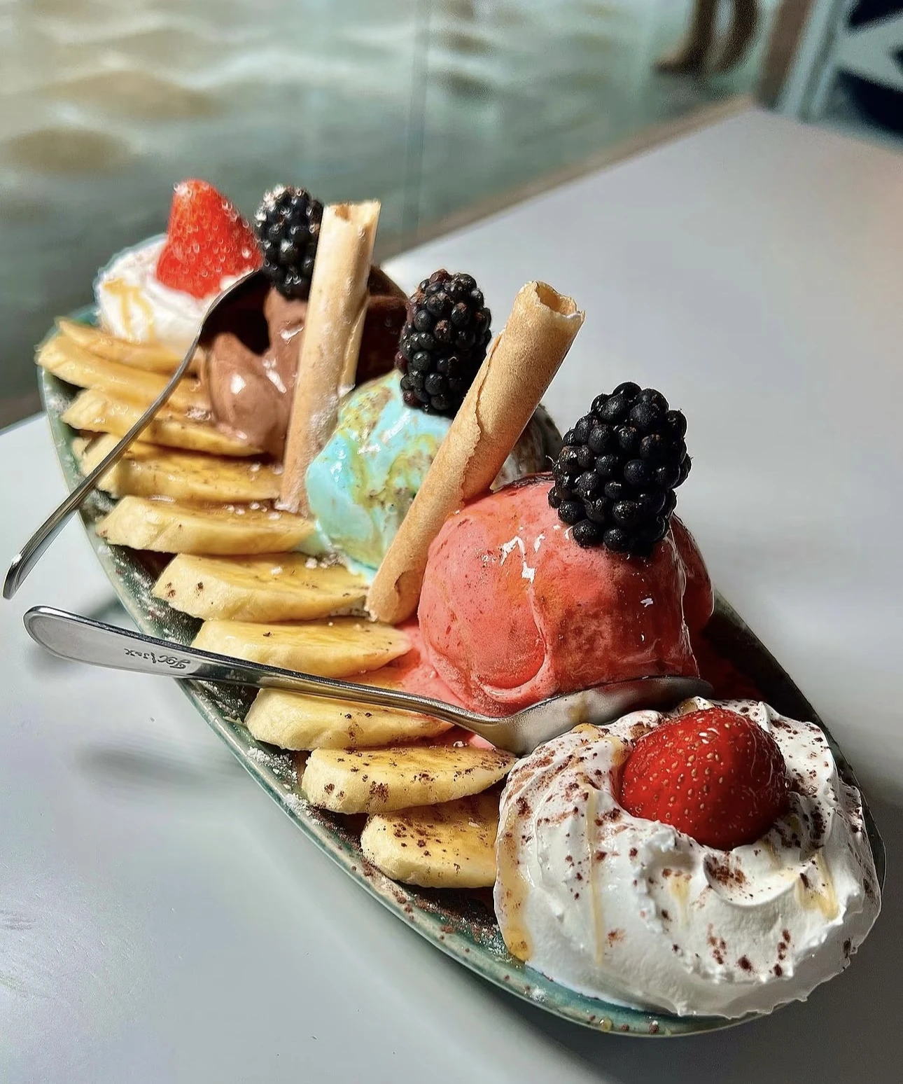 Banana split con helados de varios sabores, nata, fresas y moras